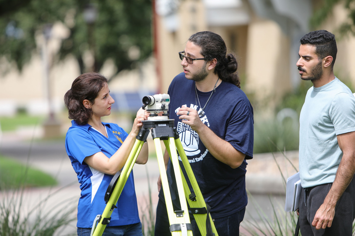 Professor and student using surveying equipment