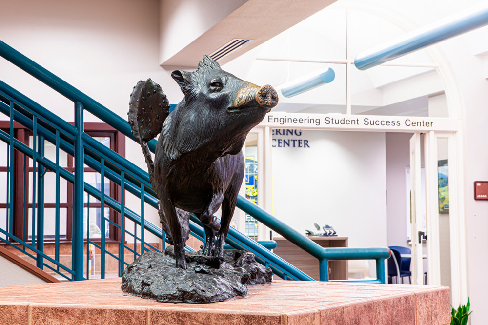 Statue in front of an office. Wall graphic reads: Engineering student success center.