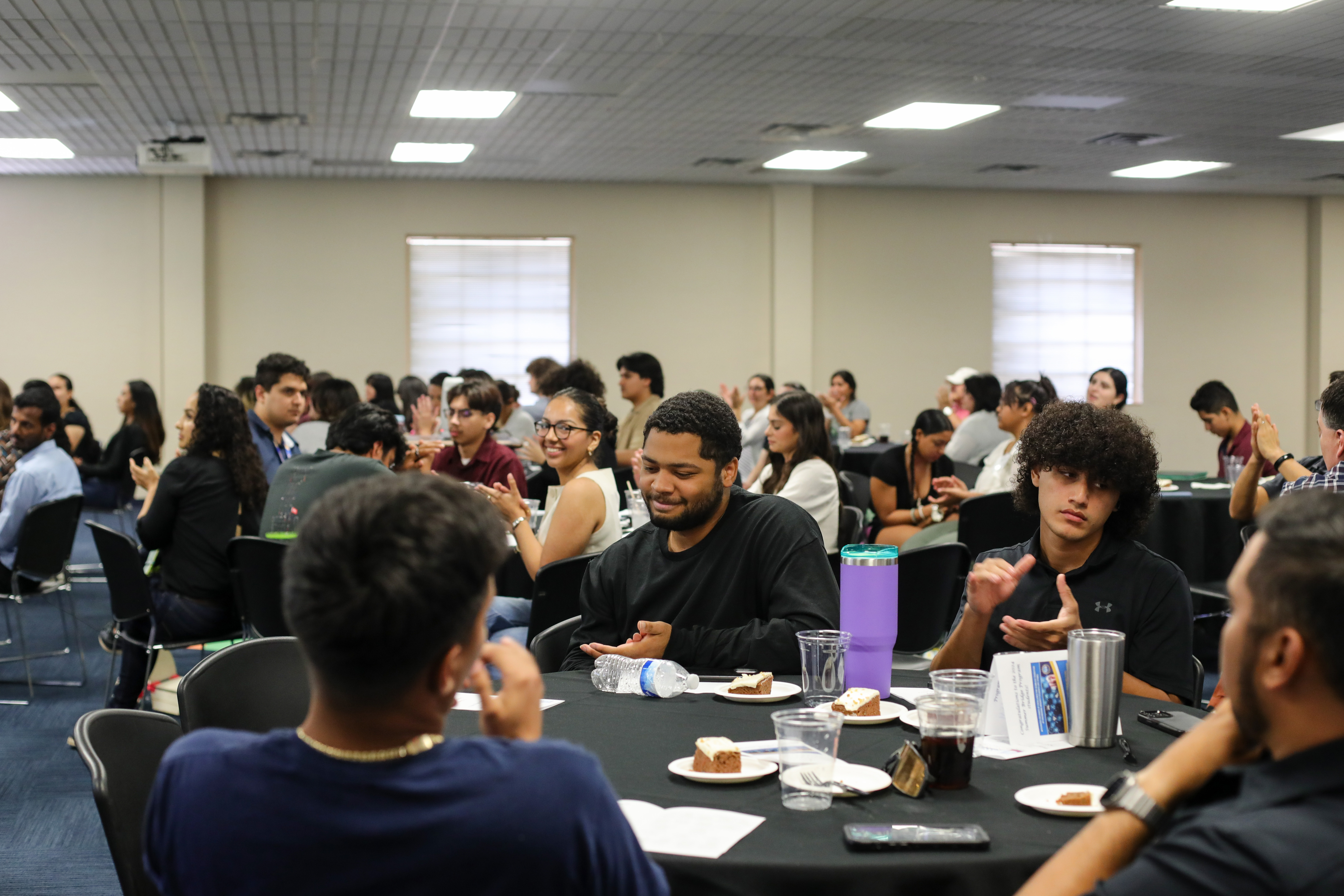 An audience seated at round tables in MSUB 221.