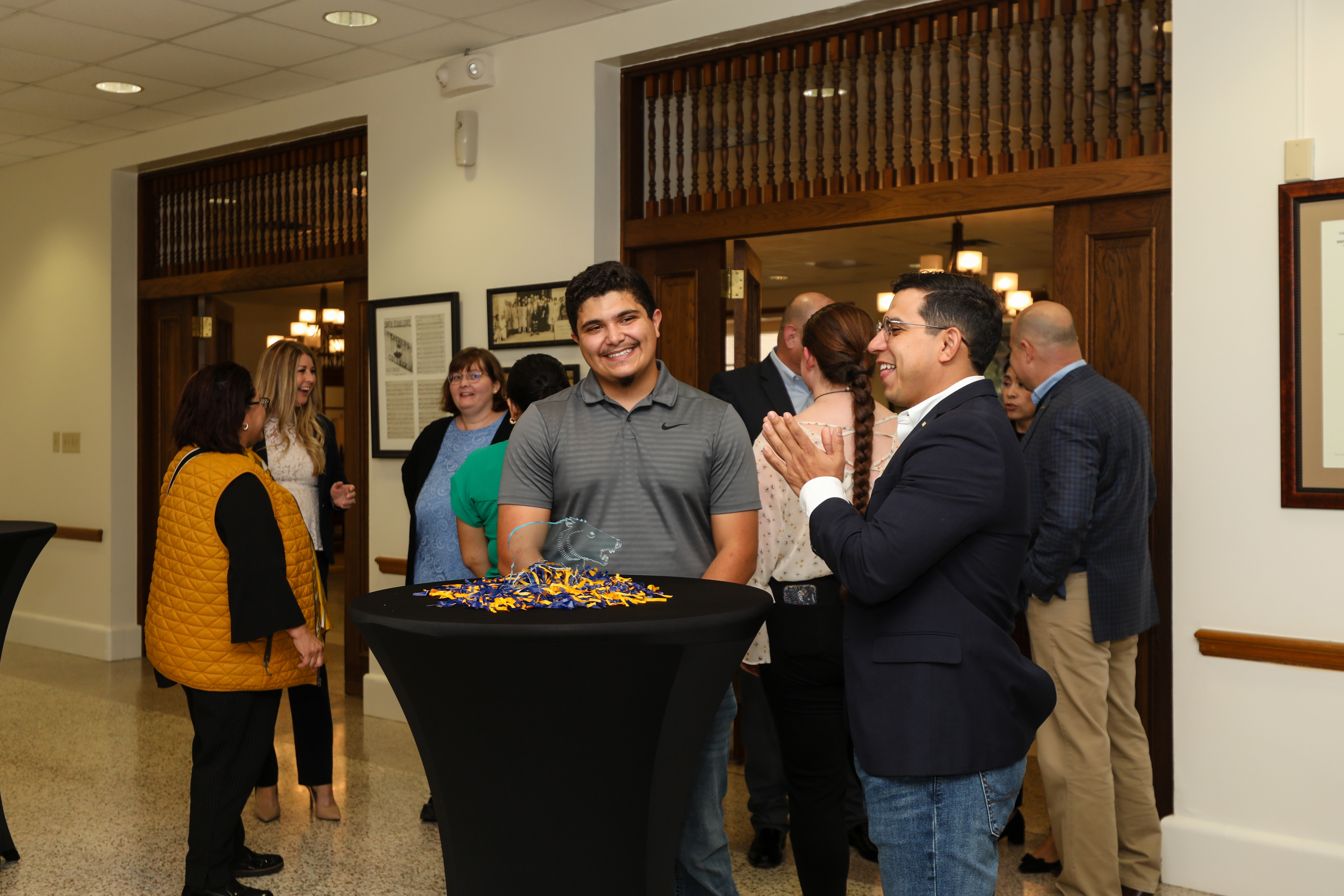 Two people stand at a cocktail table in the Founders Room.